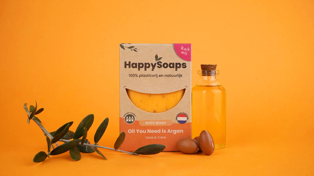Oil You Need is Argan Body Wash Bar in verpakking naast een flesje olie, noten en een tak